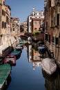 Venetian dreams: evocative image of a quiet canal, traditional houses reflected on the water. Venice, Italy