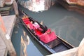 Venetian gondola at the pier. Outside is covered with black lacquer, inside the national decoration - high chairs for passengers,