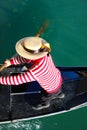 Venetian gondolier with hat rowing on gondola boat on the water of grand canal in Venice Italy Royalty Free Stock Photo