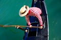 Venetian gondolier with hat rowing on gondola on grand canal in Venice in Italy Royalty Free Stock Photo