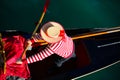 Venetian gondolier with hat and typical white and red dress while rowing on the gondola on the grand canal in Venice Italy Royalty Free Stock Photo