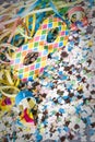 Venetian harlequin style mask with confetti and trumpets around on a marble table