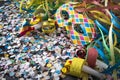 Venetian harlequin style mask with confetti and trumpets around on a marble table