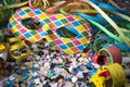 Venetian harlequin style mask with confetti and trumpets around on a marble table