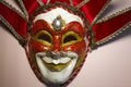 Venetian jester mask on a pink background, top view