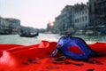 Venetian mask on red silk fabric in front of blurry Venice Royalty Free Stock Photo