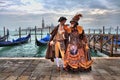 Venetian masked model from the Venice Carnival 2015 with Gondolas in the background near Plaza San Marco, Venezia, Italy Royalty Free Stock Photo