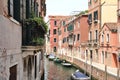 Venetian street, Venice waterway, classical buildings, Venetian architecture, moored boats, shutters, flowers in windows, Ital Royalty Free Stock Photo