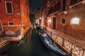 Venezia Italy. Narrow channel and gondola boats in lagoon city venice at night. Long exposure photo Royalty Free Stock Photo