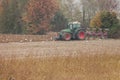 A farmer with his tractor plows the land at the end of the autumn season to pred at the end of the autumn season to prepare it for
