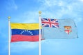 Venezuela and Fiji two flags on flagpoles and blue sky