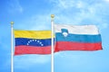 Venezuela and Slovenia two flags on flagpoles and blue sky