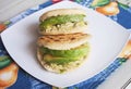 Venezuelan Arepas served on a table served with avocado and chicken
