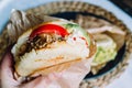 Venezuelan arepas on a table, a hand holding one arepa ready to eat