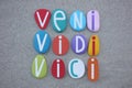 Veni, Vidi, Vici, creative latin phrase composed with hand multi colored stone letters over beach sand