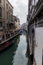 Gondolas, boats, a water channel, and a pedestrian corridor in Venice city Royalty Free Stock Photo