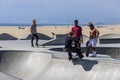 a gorgeous spring landscape at Venice Beach Skatepark at Venice Beach with young men riding skateboards and a sandy beach Royalty Free Stock Photo