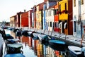 Venice, Burano island, boats on canal and colorful houses, Italy