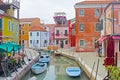 Venice, Burano island canal, small colored houses and the boats