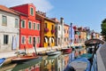 Venice Burano island canal small colored houses and the boats in sunny summer day, Italy