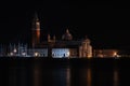 Venice canal with historical buildings and gondolas at night. Royalty Free Stock Photo