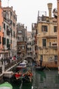 Venice canal scene depicting small boats and gondolas in a residential part of Venice in winter on a cool grey day with a people Royalty Free Stock Photo