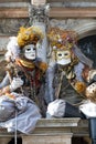 Venice Carnival Characters in a colorful gold and brown Carnival costumes and Venice masks in Saint Marcs Square Venice Italy