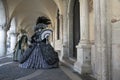 Two Venice masks dressed in a silver and black and gold and turquoise costumes at Venice Carnival in February, Venice Italy