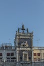 Venice, Clock and bell tower in Renaissance style in San Marco square with the statues called Mori di Venezia, UNESCO world