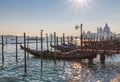 Venice at dusk. Gondolas at sunset with dome in background