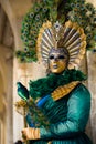 VENICE, FEBRUARY 10: An unidentified woman in typical dress in green and gold colors poses during traditional Venice Carnival