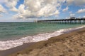 Venice fishing pier in Florida on sunny summer day. Bright seascape with surf waves crashing on sandy beach Royalty Free Stock Photo