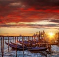 Venice with gondolas against colorful sunset in Italy
