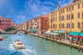 Venice Grand canal with gondolas, boats, bridge, and colorful houses. Italy in summer bright day