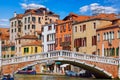 Venice, Italy. Antique stone bridge on the canal with boats and motorboats