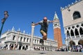 VENICE, ITALY - APRIL 19, 2021: man jump near saint mark bell tower and palace of Doge in Venice, Italy Royalty Free Stock Photo