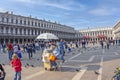 People visit Piazza San Marco square in Venice, Italy with doves flying around Royalty Free Stock Photo