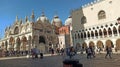 VENICE, ITALY - APRIL 19, 2021: people walking near saint mark bell tower and palace of Doge in Venice, Italy Royalty Free Stock Photo