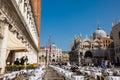 Restaurants and tourists at the famous Saint Mark Square of Venice in a beautiful sunny early spring Royalty Free Stock Photo