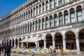 Restaurants and tourists at the famous Saint Mark Square of Venice in a beautiful sunny early spring Royalty Free Stock Photo