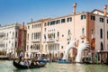 VENICE, ITALY - APRIL, 2018: Tourists at a gondola in front of the hands sculpture created by Spanish artist Lorenzo Quinn in the