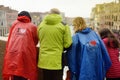 VENICE, ITALY - APRIL 23, 2019: Tourists wearing raincoats on bridge of Venice admiring view of Grand Canal