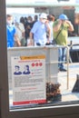 Venice, Italy - August 10, 2020: Coronavirus warning sign and people wearing masks at Actv vaporetto waterbus station. During the Royalty Free Stock Photo