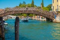 VENICE, ITALY - August 27, 2021: Police boat sailing under the bridge on a typical Venetian water street canals