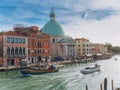 Venice, Italy - 17.10.2023: Boats in Grand Canal and Banca Monte dei Paschi di Siena church in the background. Stunning