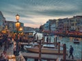 Venice, Italy - 17.10.2023: Busy Rialto bridge area with tourist and traffic at dusk. Popular city landmark location