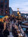 Venice, Italy - 17.10.2023: Busy Rialto bridge area with tourist and traffic at dusk. Popular city landmark location