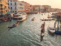 Venice, Italy - 17.10.2023: Busy water traffic with boats, taxi and gondolas in Rialto bridge area of the Grand channel. Warm