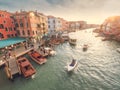 Venice, Italy - 17.10.2023: Busy water traffic with boats, taxi and gondolas in Rialto bridge area of the Grand channel. Warm