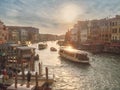 Venice, Italy - 17.10.2023: Busy water traffic with boats, taxi and gondolas in Rialto bridge area of the Grand channel. Warm